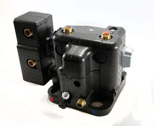 Daikin Hydraulikkomponente mit mehreren Anschlüssen, einschließlich einer elektrischen Steuerung, auf glattem Untergrund.